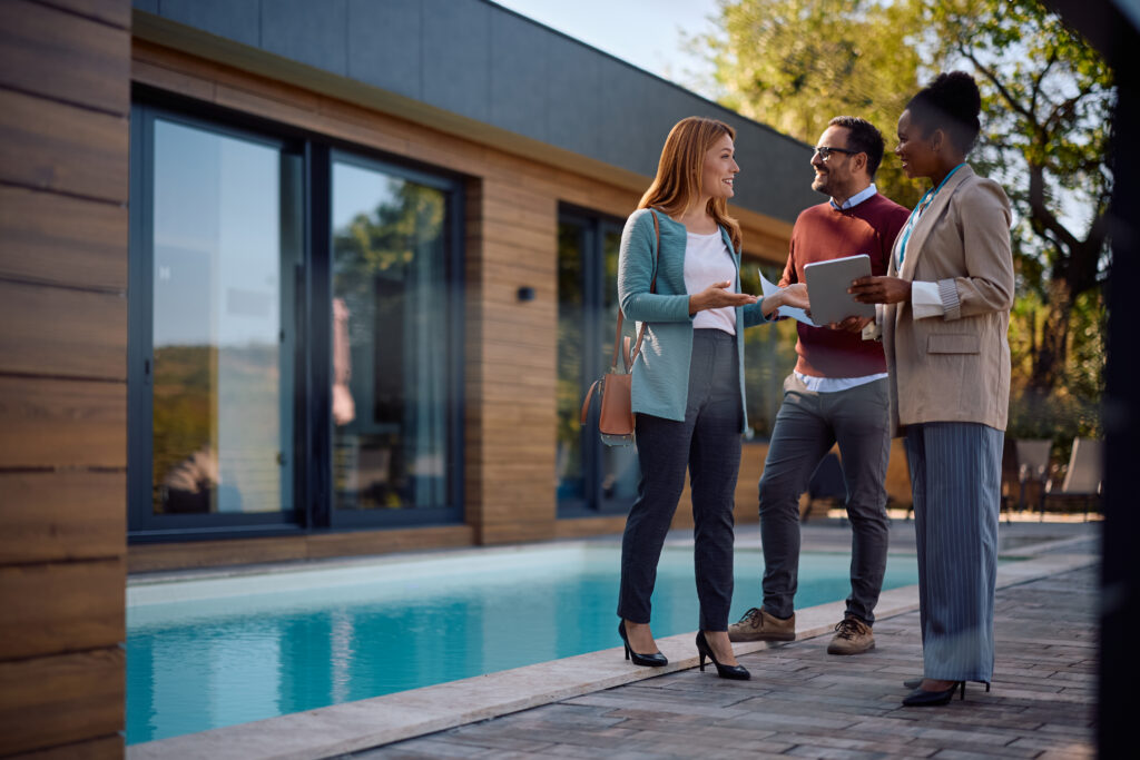 Realtor showing potential buyers around a house for sale