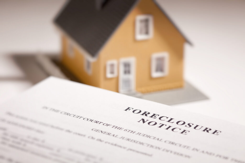 Foreclosure notice with house figurine